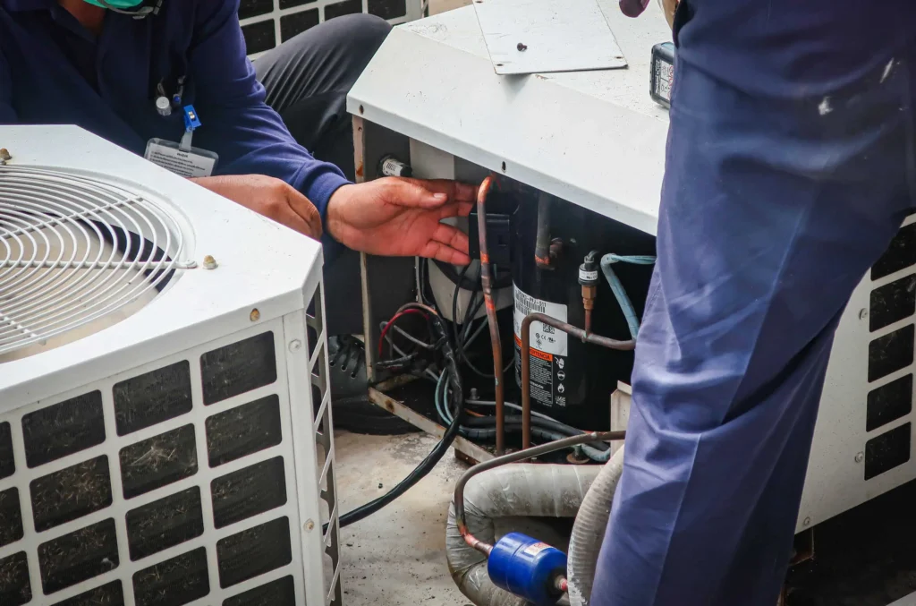 Technicians Servicing AC Compressor