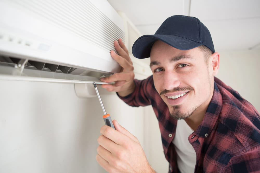 Portrait of mid-adult male technician repairing ac